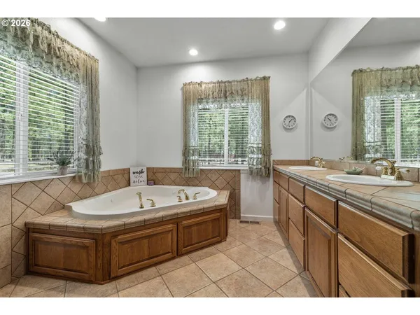 a spacious bathroom with a tub sink and mirror