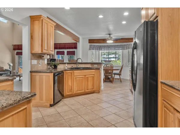 a kitchen with stainless steel appliances granite countertop a sink and a refrigerator