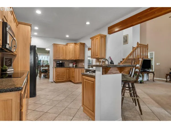 a kitchen with kitchen island granite countertop wooden cabinets and stainless steel appliances