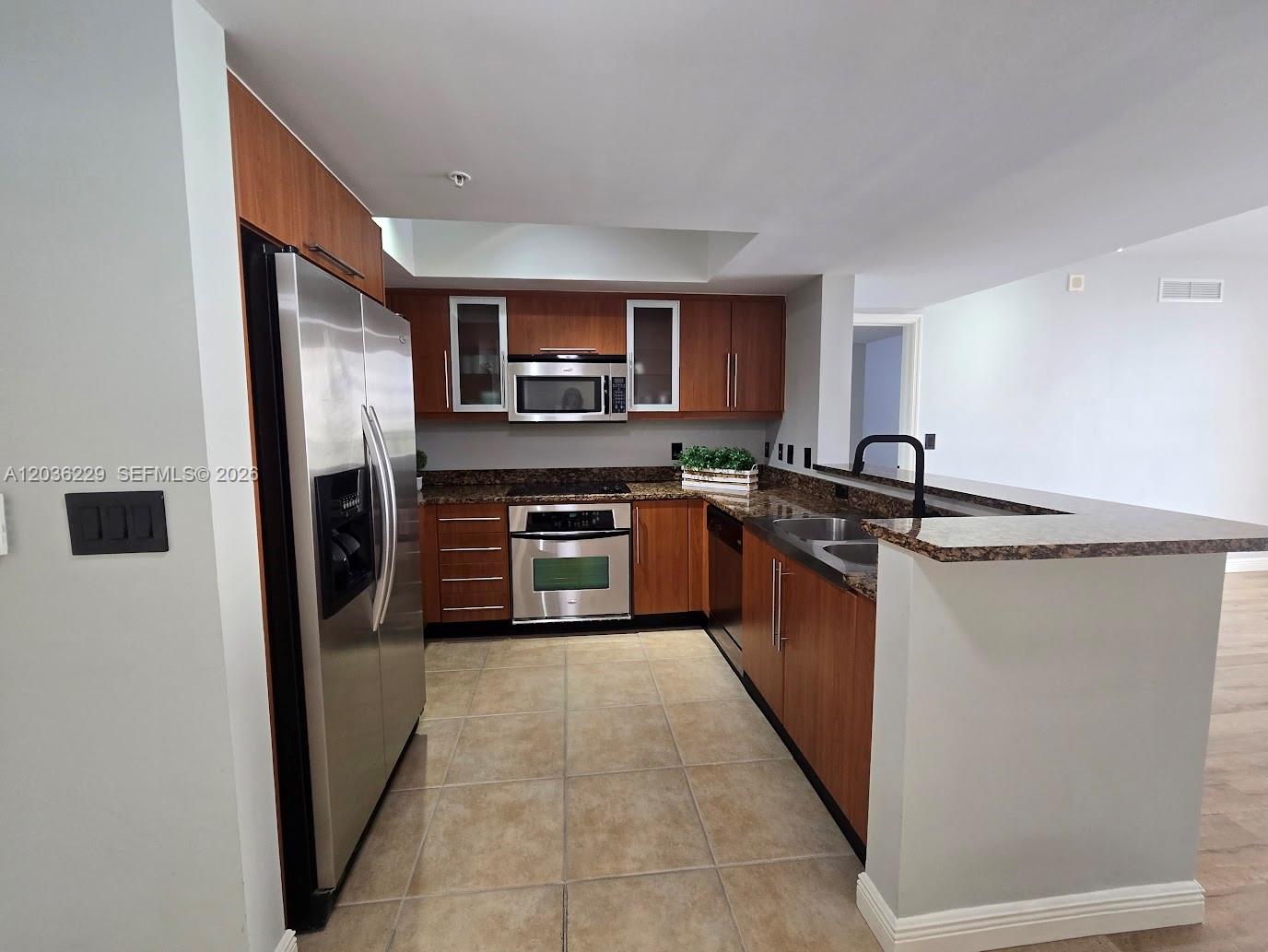 888 Douglas Road, Unit 605 Coral Gables, FL 33134 - Photo 6 of 21 a kitchen with stainless steel appliances granite countertop a refrigerator and a sink