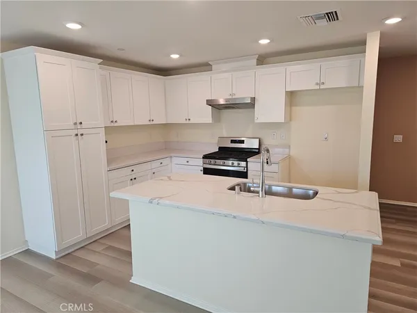 a kitchen with kitchen island a stove a sink and a refrigerator