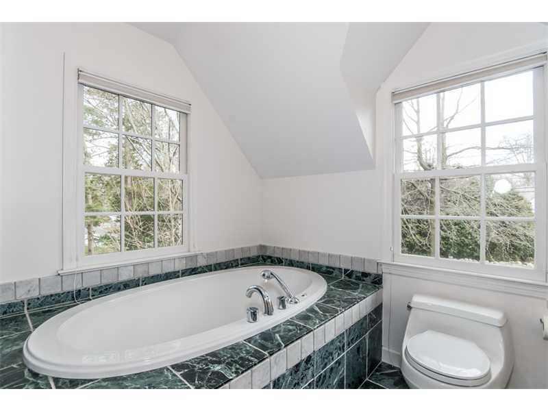 5 Dorchester Lane Riverside, CT 06878 - Photo 14 of 22 a bathroom with a granite countertop sink a window and a bathtub
