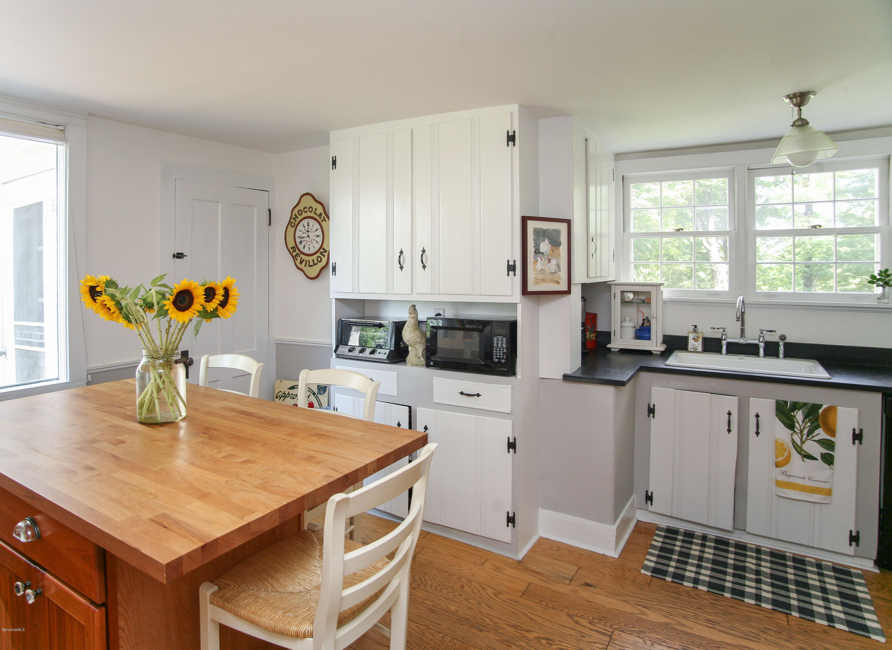 570 Devon Road Lee, MA 01238 - Photo 19 of 42 a kitchen with stainless steel appliances granite countertop a stove a refrigerator a sink a dining table and chairs with wooden floor