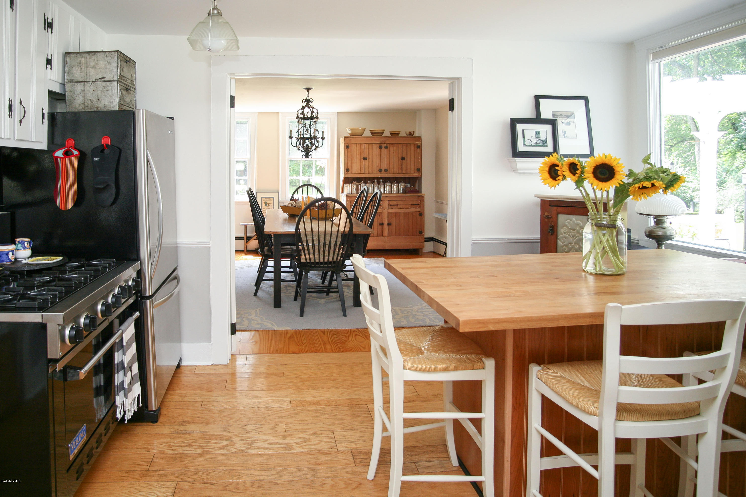 570 Devon Road Lee, MA 01238 - Photo 20 of 42 a dining room with stainless steel appliances granite countertop a stove top oven a dining table and chairs with wooden floor