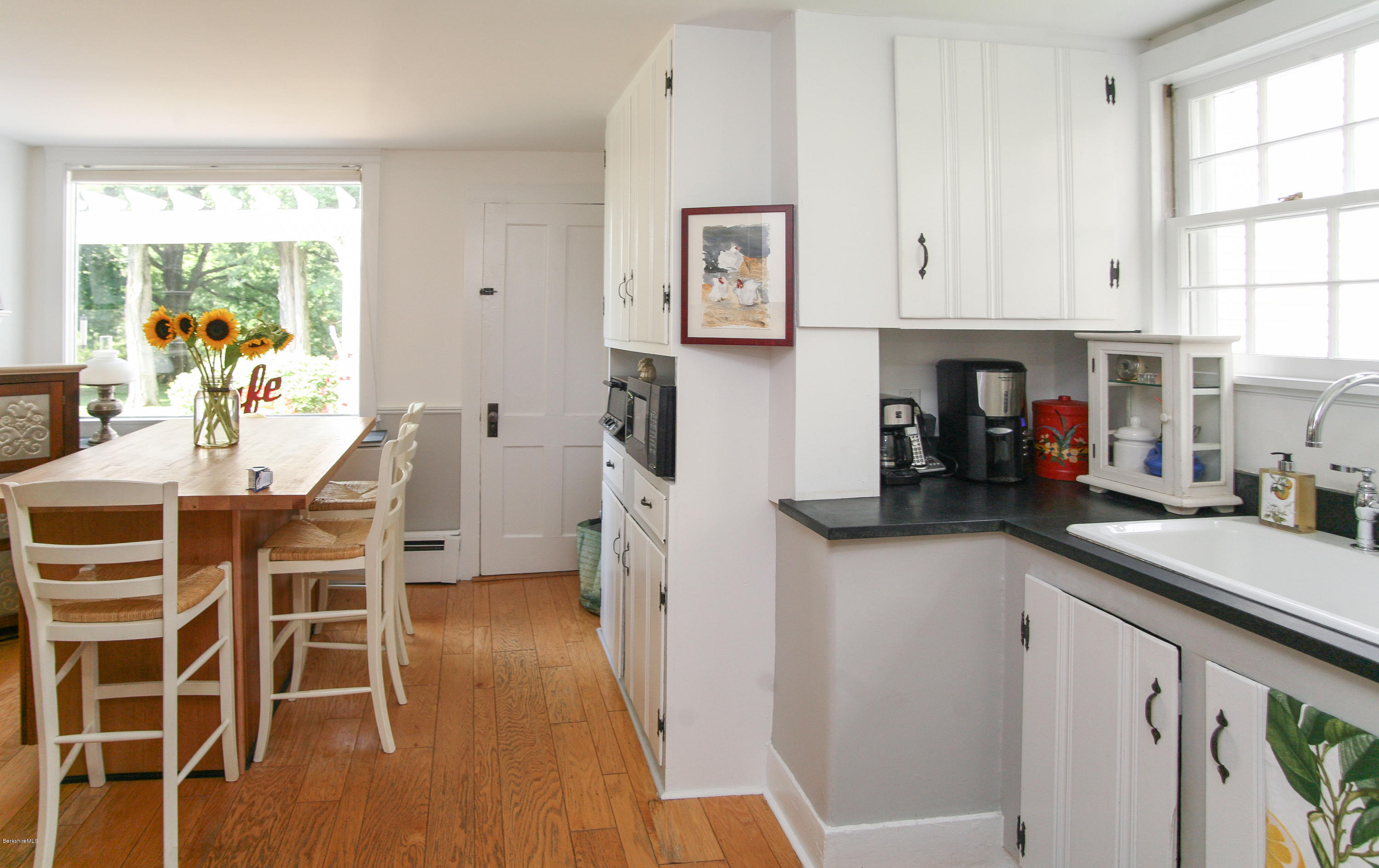 570 Devon Road Lee, MA 01238 - Photo 22 of 42 a kitchen with stainless steel appliances granite countertop a refrigerator a sink a stove and white cabinets next to a window