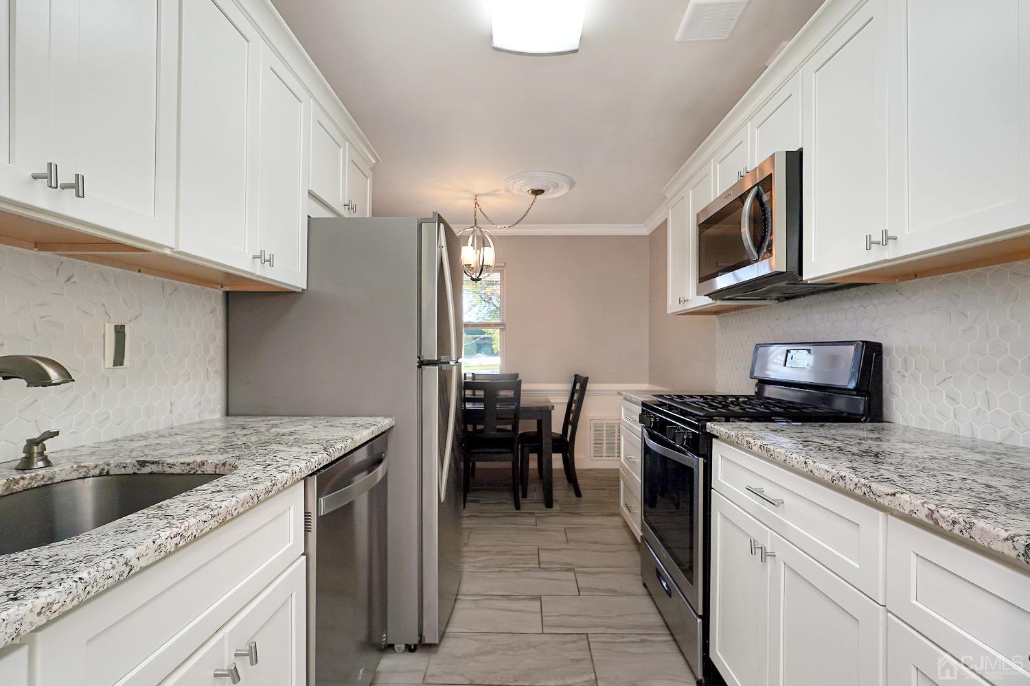 7 Haven Drive Old Bridge, NJ 07747 - Photo 8 of 24 a kitchen with stainless steel appliances granite countertop a sink stove and refrigerator