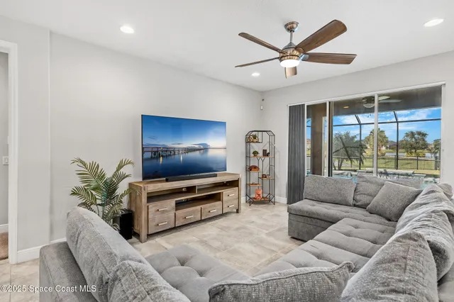 a living room kitchen with white cabinets and stainless steel appliances