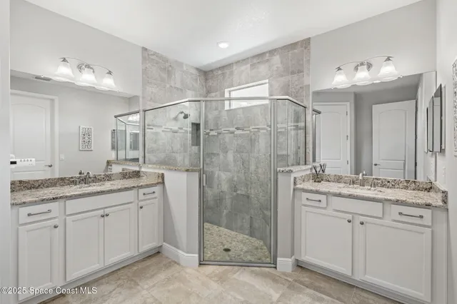 a bathroom with a granite countertop sink a mirror and a shower