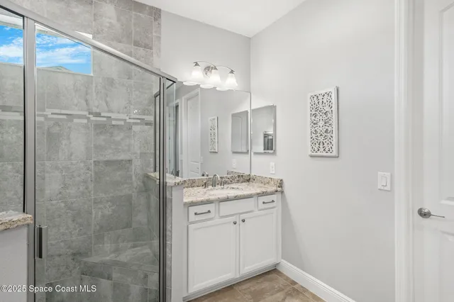 a bathroom with a granite countertop sink a shower and a mirror