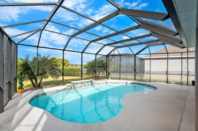 a view of a swimming pool with a patio and a yard