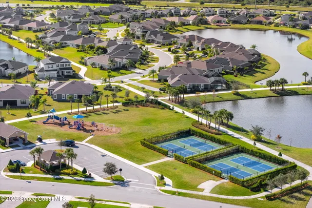 an aerial view of residential houses with outdoor space and ocean view