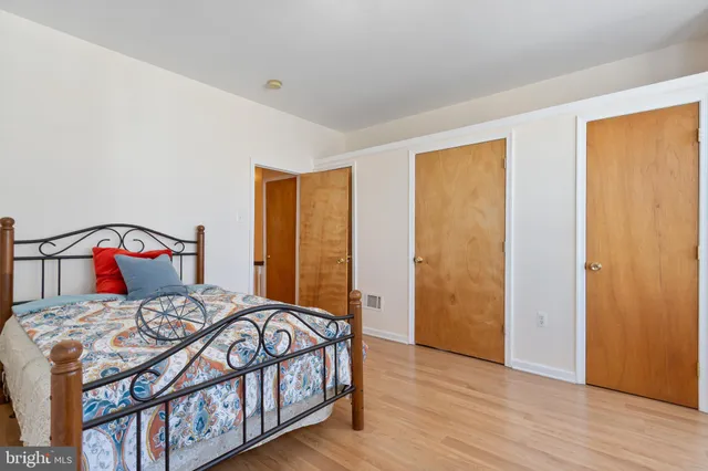 a bedroom with a bed with wooden floor