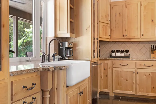 a kitchen with stainless steel appliances granite countertop a sink a stove and cabinets