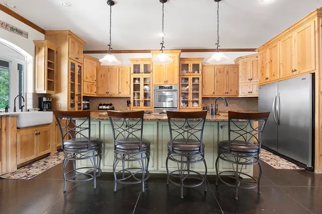 a kitchen with stainless steel appliances a dining table chairs and granite counter tops
