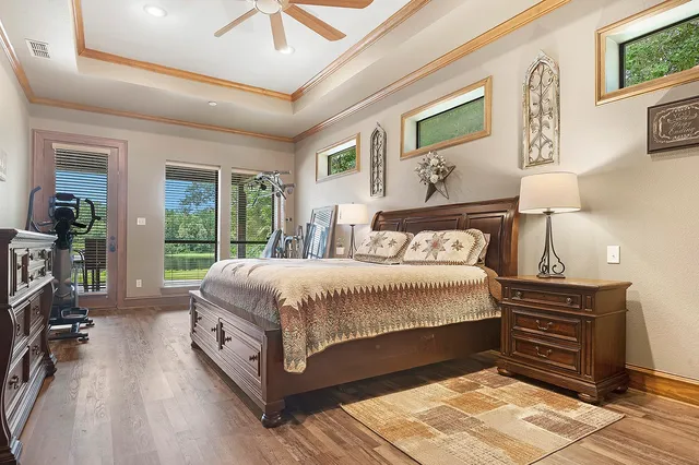 a spacious bedroom with a balcony a bed and a dresser next to a window