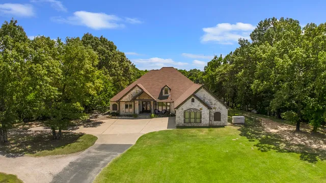 a front view of a house with a yard and trees