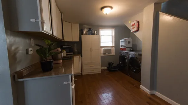 a kitchen with a refrigerator a stove and wooden floor