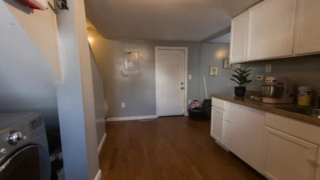 a kitchen with cabinets and wooden floor