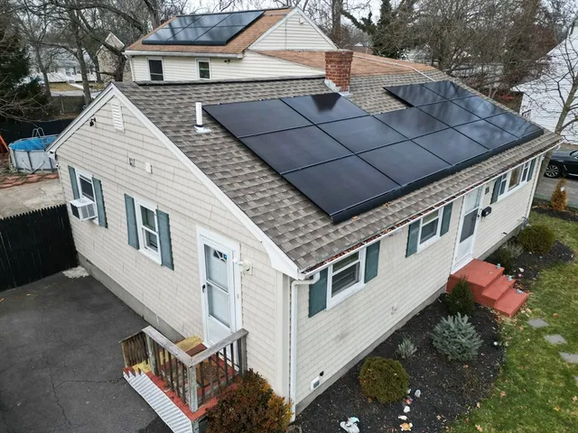 a aerial view of a house with swimming pool and large trees