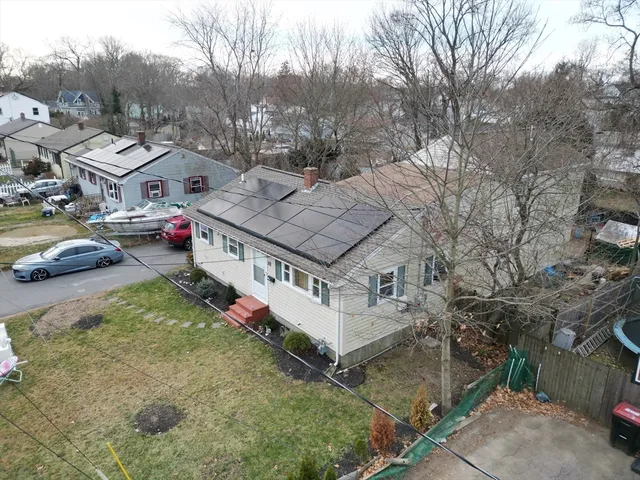an aerial view of a house with swimming pool and large trees