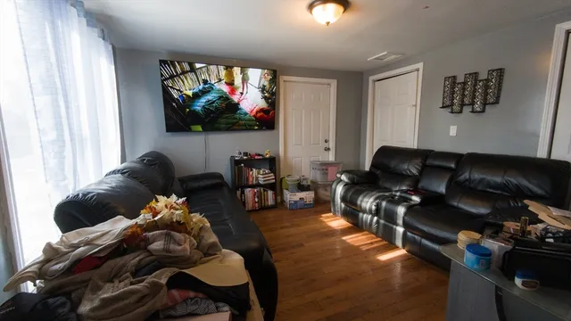 a living room with furniture a window and a flat screen tv