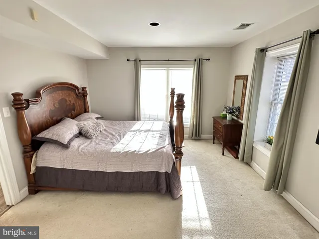 a bedroom with a bed a mirror and a dresser