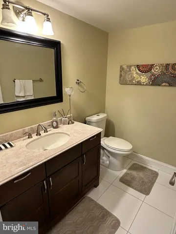 a bathroom with a granite countertop sink toilet and mirror