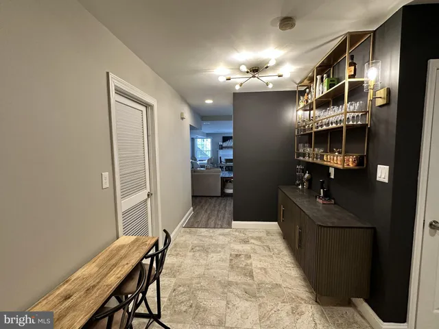 a view of a hallway with furniture and chandelier