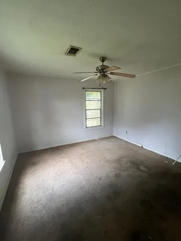 en empty room with windows and ceiling fan view