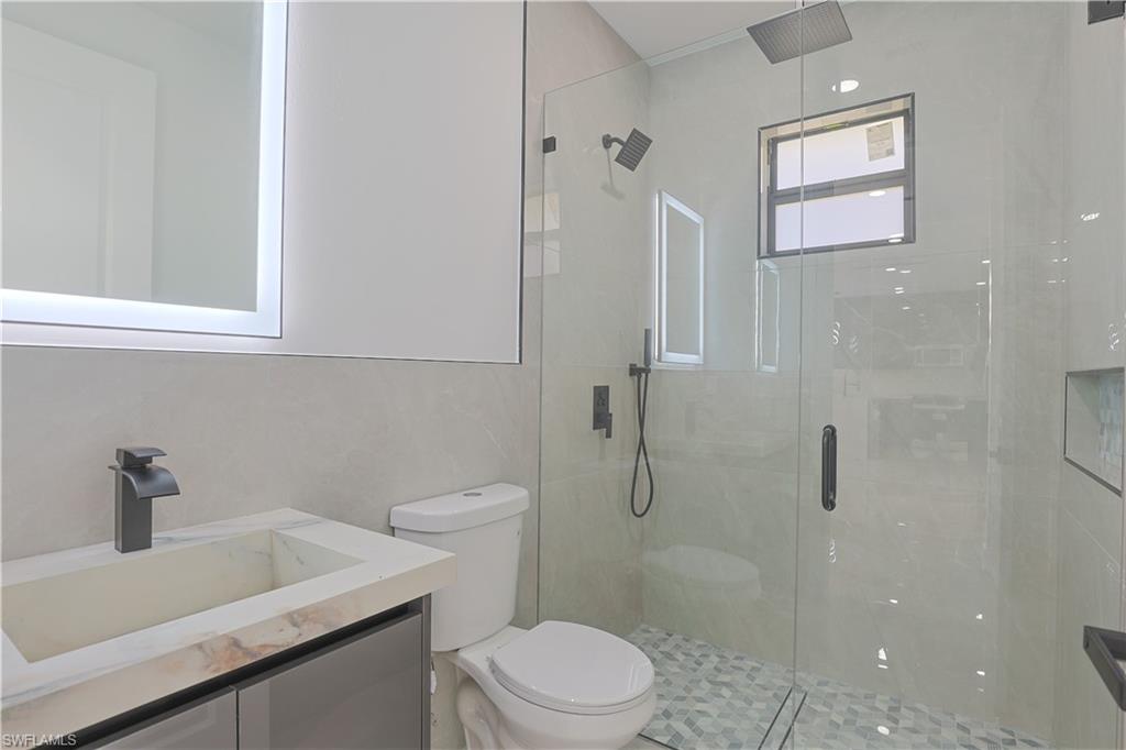 809 Williams Avenue Lehigh Acres, FL 33972 - Photo 16 of 33 a bathroom with a sink a toilet and shower