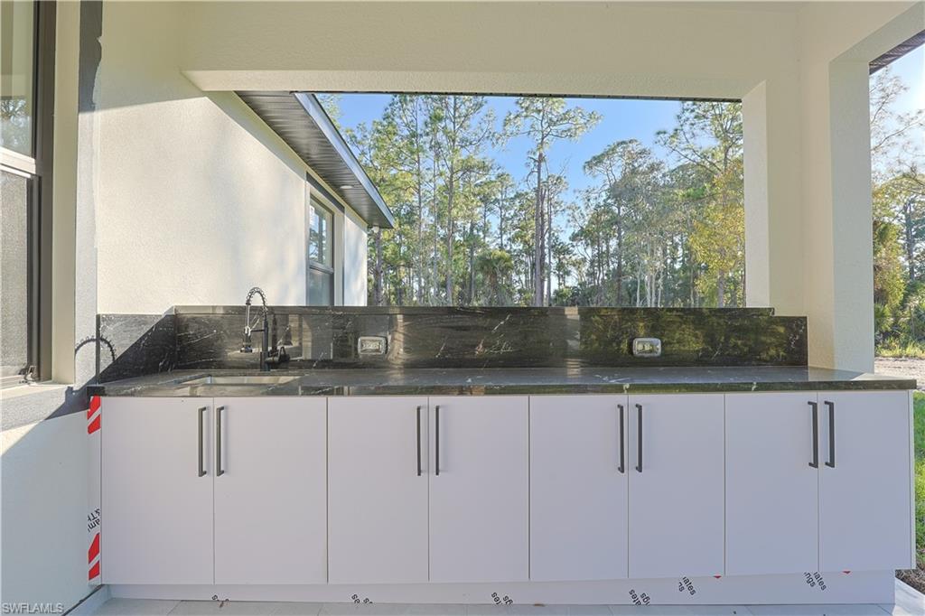 809 Williams Avenue Lehigh Acres, FL 33972 - Photo 22 of 33 a kitchen with granite countertop a sink and a window