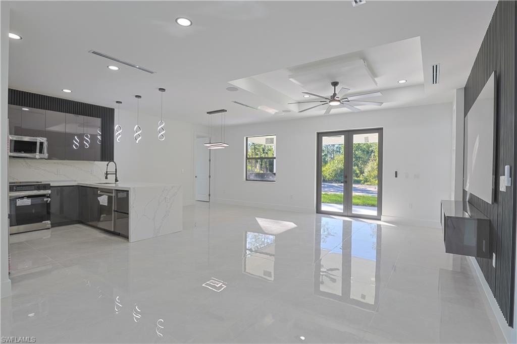 809 Williams Avenue Lehigh Acres, FL 33972 - Photo 4 of 33 a living room with furniture a ceiling fan and a flat screen tv