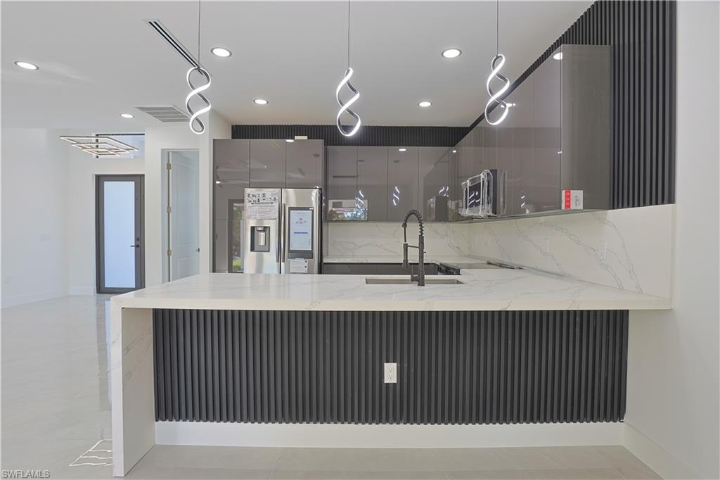809 Williams Avenue Lehigh Acres, FL 33972 - Photo 5 of 33 a kitchen with a sink a counter space and stainless steel appliances