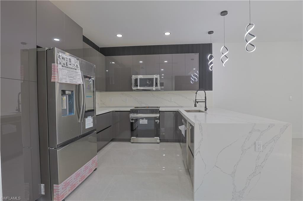 809 Williams Avenue Lehigh Acres, FL 33972 - Photo 6 of 33 a large kitchen with stainless steel appliances a refrigerator and a sink