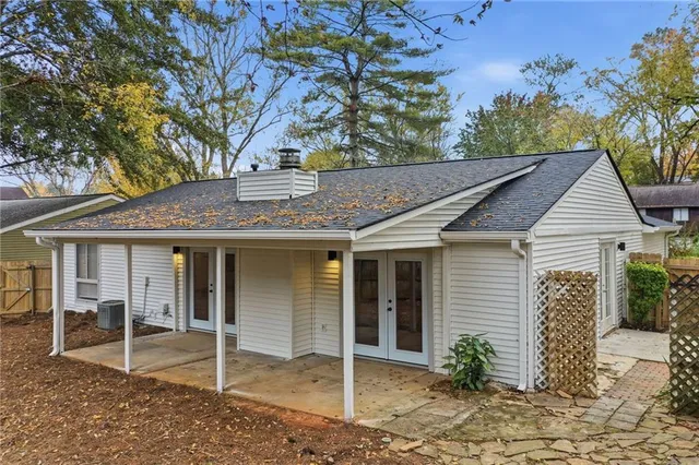 a view of a house with a garage and large tree