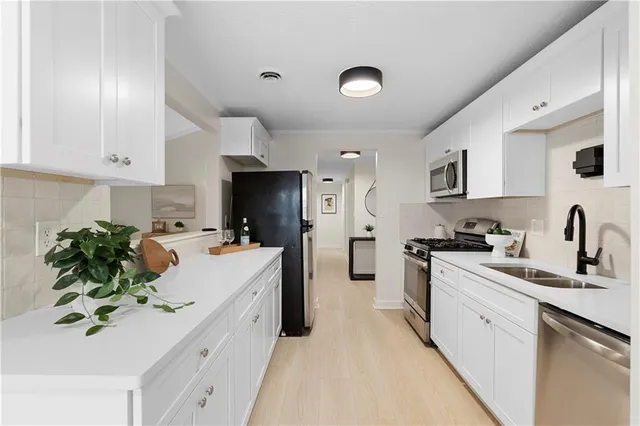 a kitchen with a sink white cabinets and white appliances