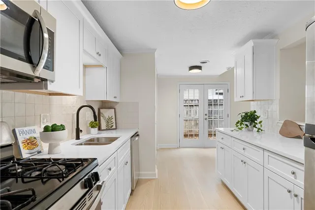 a kitchen with white cabinets and appliances