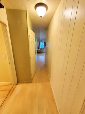 a view of a hallway with wooden floor and staircase