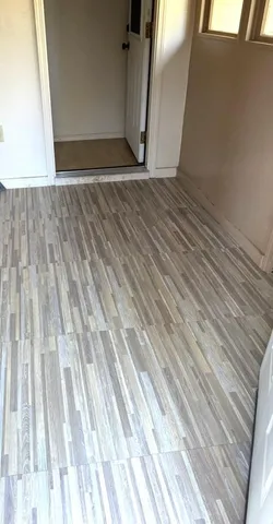 en empty room with windows and chandelier fan