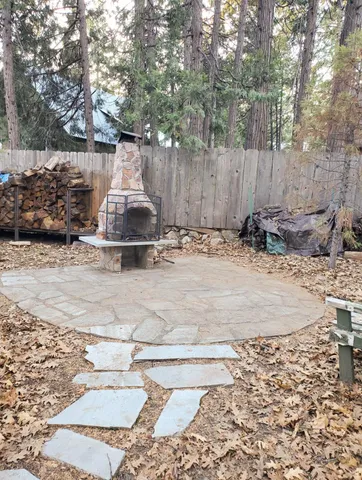 a view of a backyard with table and chairs and wooden fence