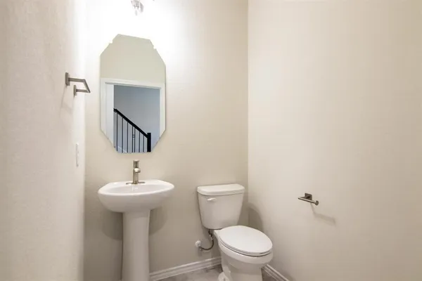 a bathroom with a sink toilet and mirror