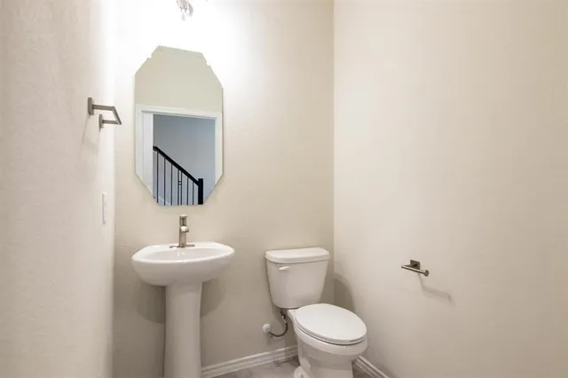 a bathroom with a sink toilet and mirror
