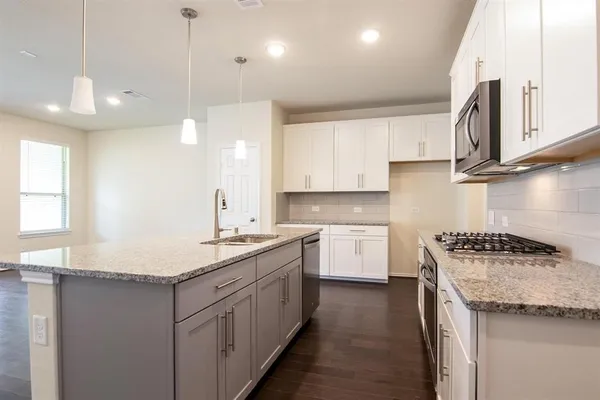 a kitchen with a sink stove and cabinets