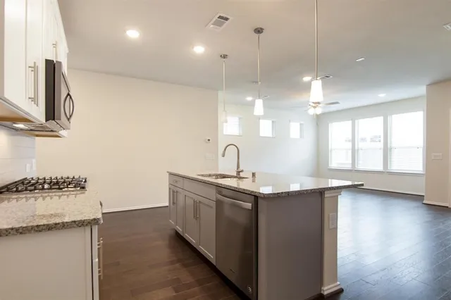 a kitchen with a sink stove and wooden floor