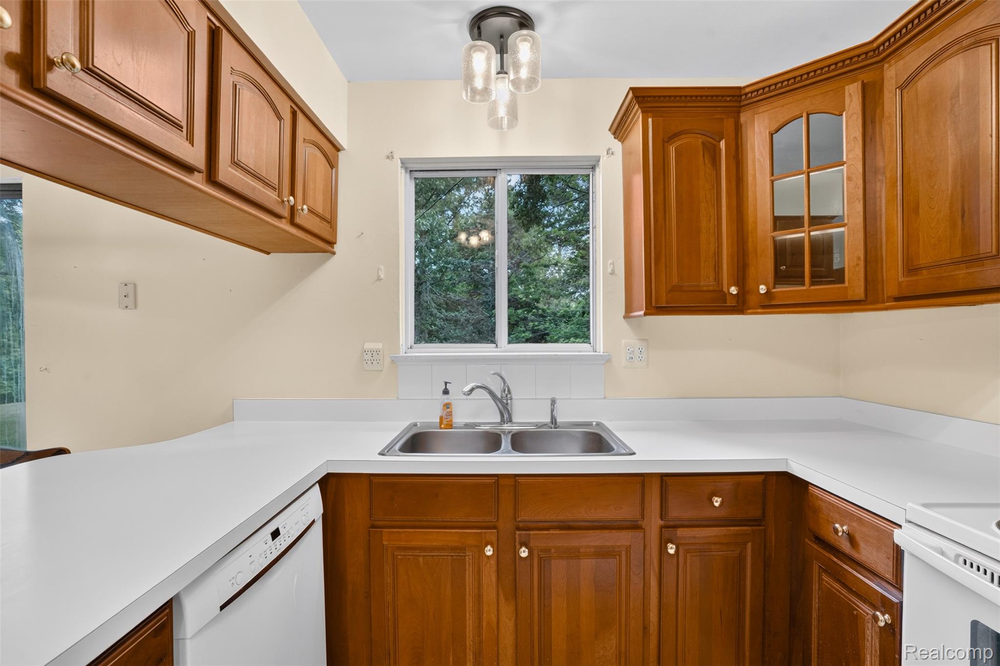 16955 English Road Manchester, MI 48158 - Photo 11 of 37 Kitchen featuring wood cabinetry, white countertops, a double basin stainless steel sink, and a built-in dishwasher