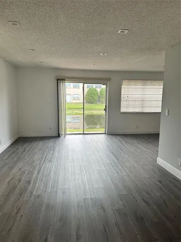 a view of an empty room with a closet fire place and window