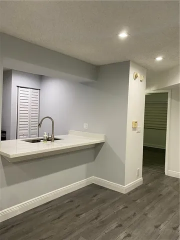 a view of kitchen with stainless steel appliances cabinets and wooden floor