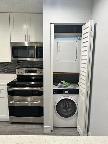 a kitchen with a sink wooden floor and stainless steel appliances