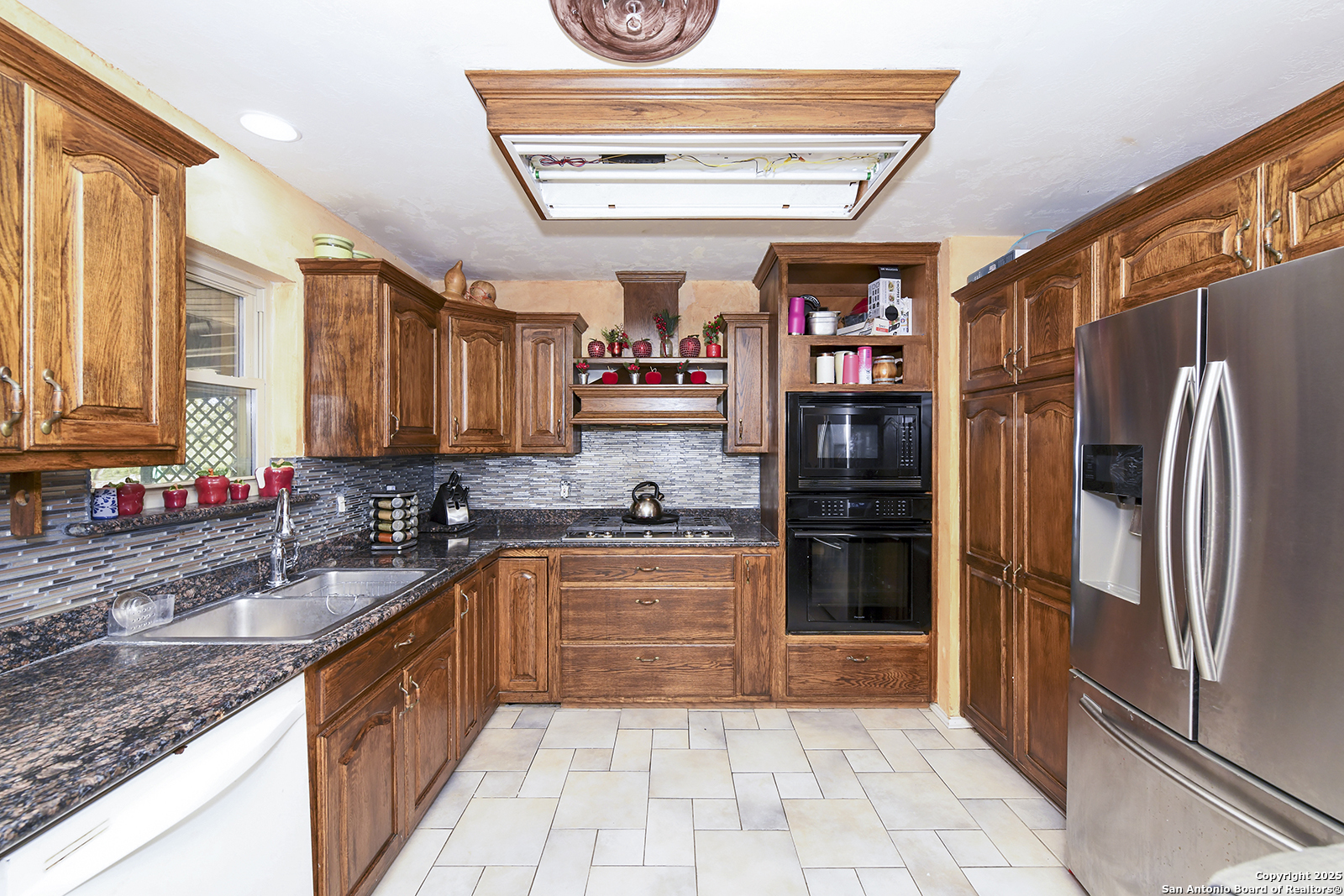 4720 Rakowitz Road Adkins, TX 78101 - Photo 11 of 35 a kitchen with stainless steel appliances granite countertop a refrigerator and a sink