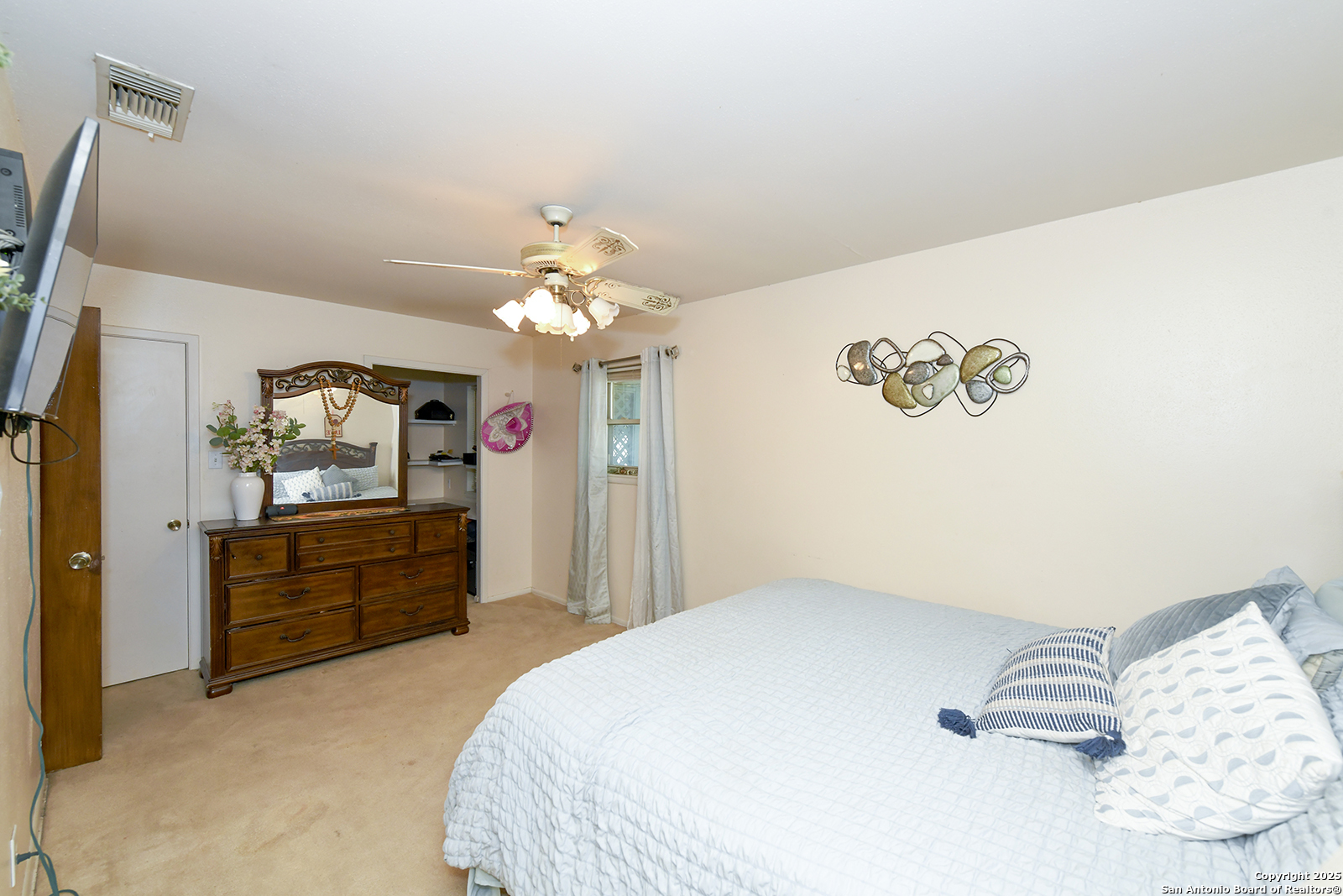 4720 Rakowitz Road Adkins, TX 78101 - Photo 12 of 35 a bedroom with a bed and a chandelier